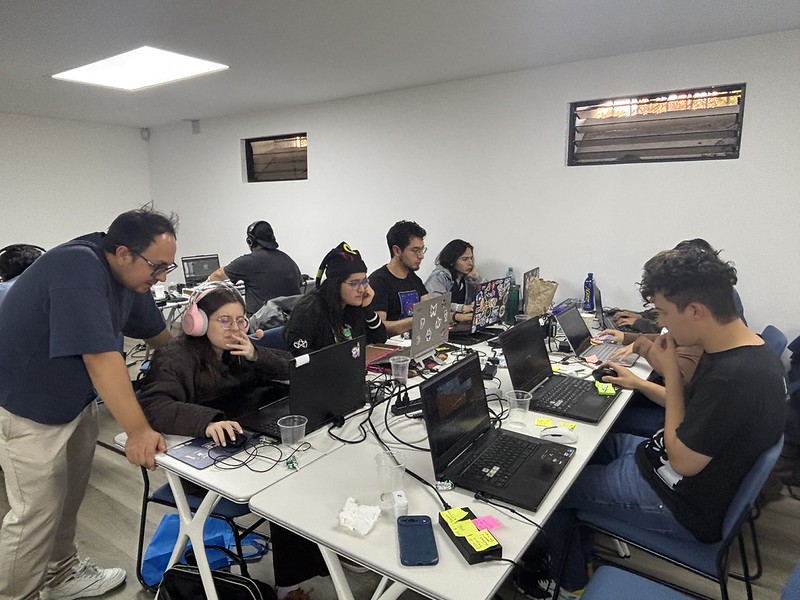 Equipo trabajando alrededor de computadoras portátiles